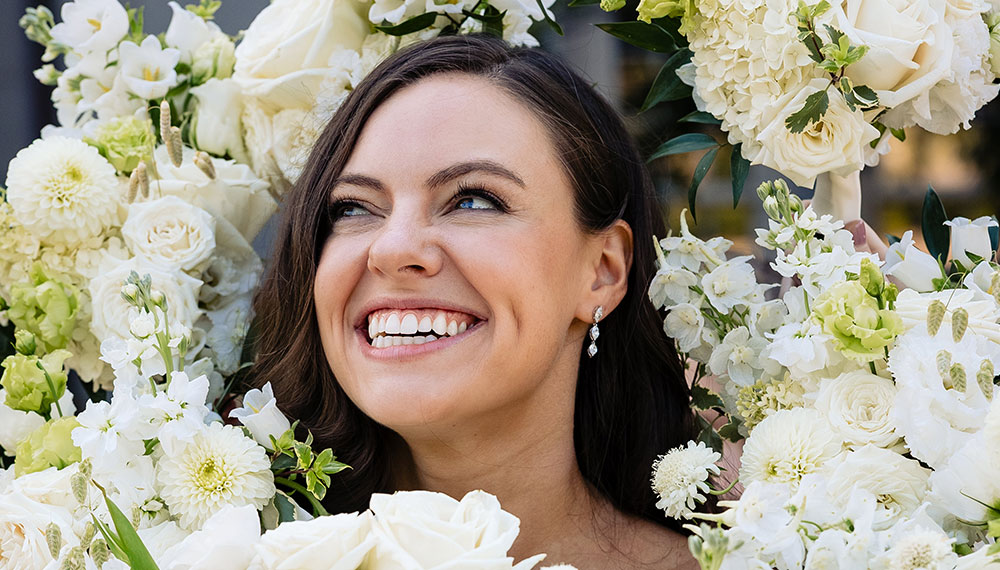 woman smiling surrounded by flowers