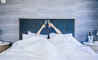 two hands toasting champagne under blankets